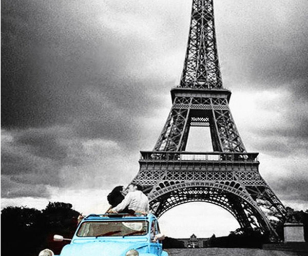 Pora melsvame automobilyje prie pilko Paryžiaus bokšto